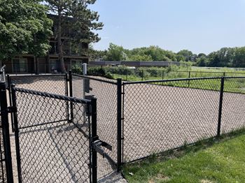 a black chain link fence with a tennis court in the background